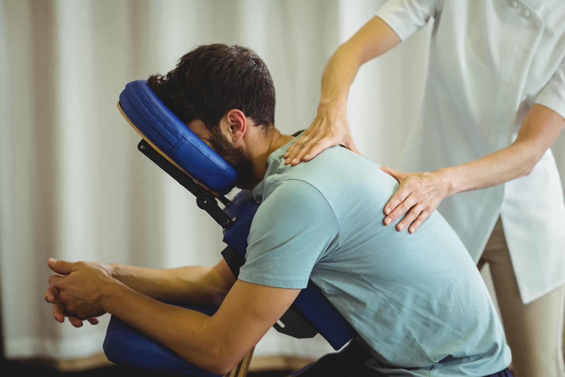 Physiotherapist giving back massage to a patient