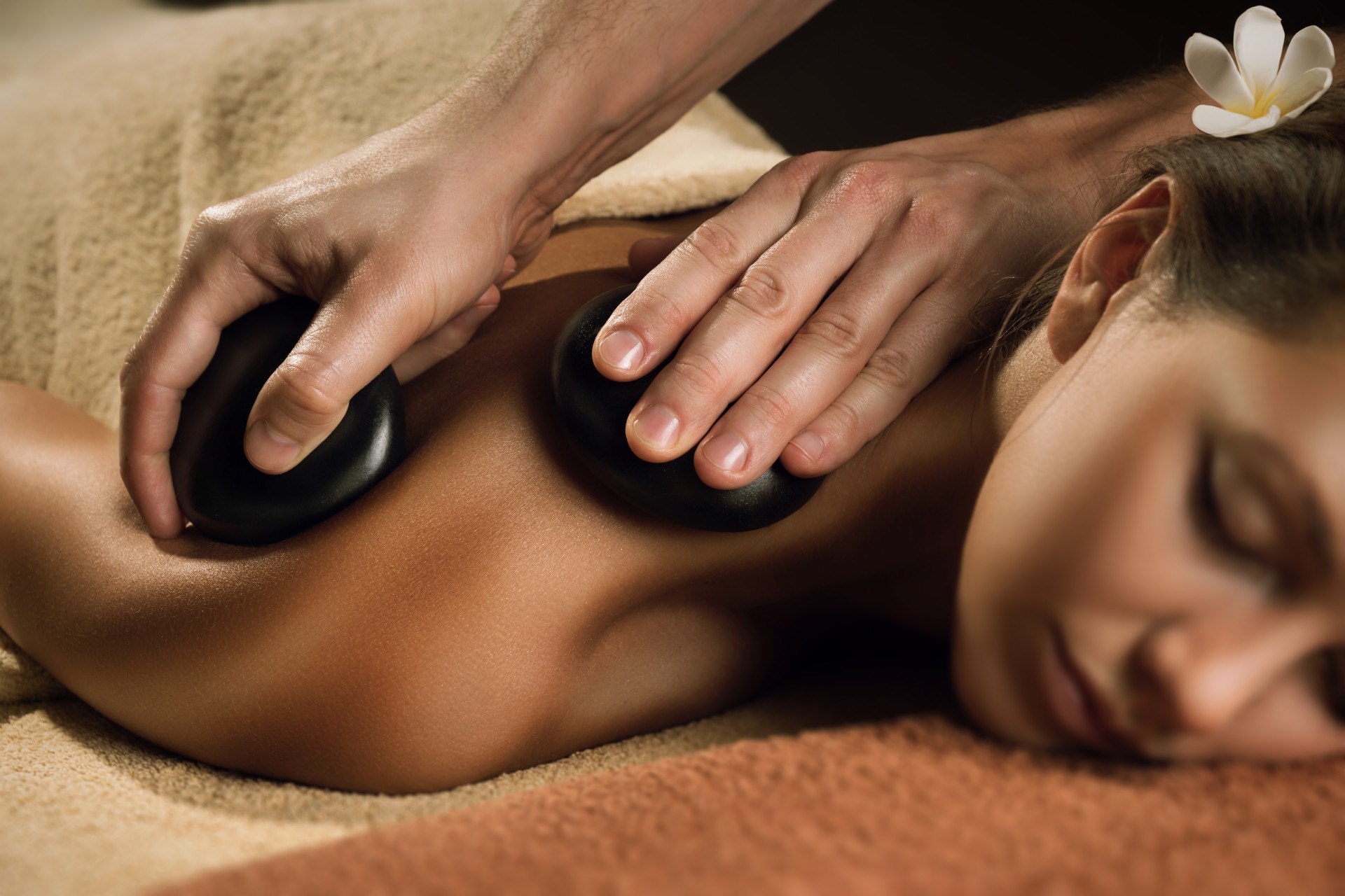 Beautiful girl has stone massage.